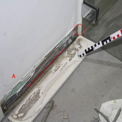 Austretendes Wasser aus einer bodengleichen Dusche unterhalb der Sockelfliese.